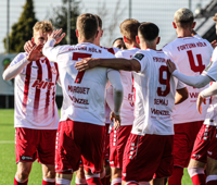 Die Mannschaft von Fortuna Köln bildet eine Jubeltraube auf dem Fußballplatz beim SV Straelen